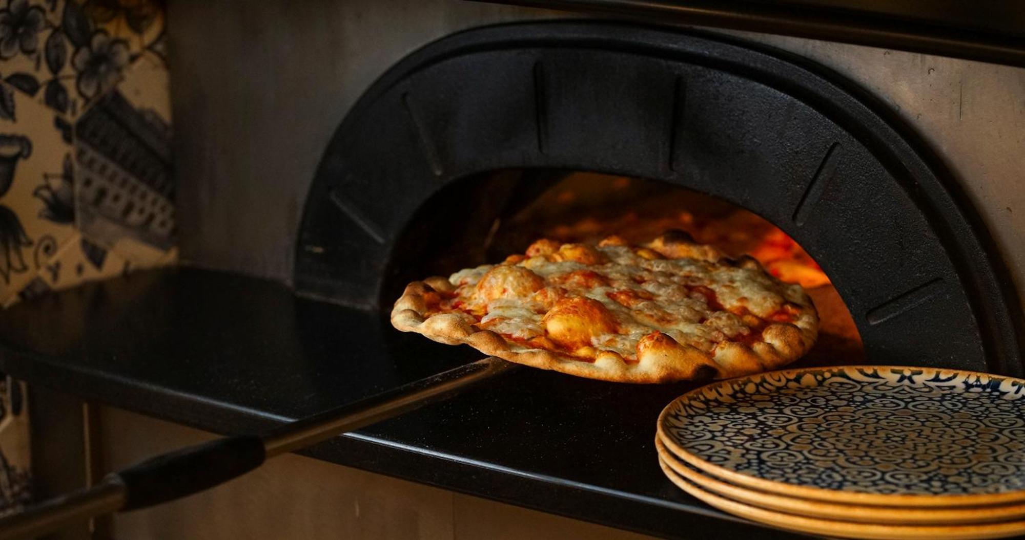 Eme Catedral Mercer Hotel Sevilla Exteriör bild Pizza being removed from a wood-fired oven